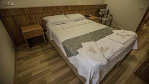 Un dormitorio con una cama con toallas blancas. en Hotel Cenka Ephesus, en Selçuk