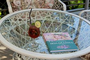 um livro e uma bebida sentados numa mesa em Villa Polianna em Sochi