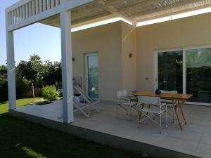 eine Terrasse mit einem Holztisch und Stühlen darauf in der Unterkunft La Conchiglia in Petrosino