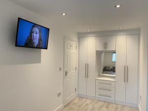 a living room with a flat screen tv on the wall at sark house Apartment Chorlton manchester in Manchester