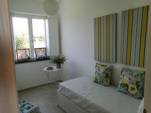 a small bedroom with a bed and two windows at La Conchiglia in Petrosino