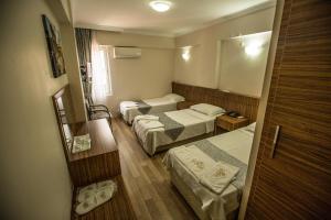 a hotel room with two beds and a mirror at Hotel Cenka Ephesus in Selcuk