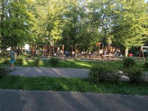 a park with a playground with people in it at Pokoje nad Rabą in Myślenice