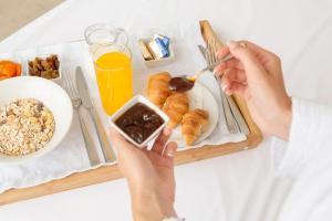 a person eating a plate of breakfast food on a table at Hotel Royal Inn in Belgrade