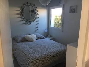 a bedroom with a bed with a mirror on the wall at Appartement T2 refait à neuf, piscine in Quiberon
