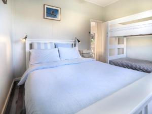 um quarto com uma grande cama branca num quarto em Tallowood beachfront cottage em Bonny Hills