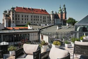 balkon z krzesłami i doniczkami oraz budynkami w obiekcie Hotel Copernicus w Krakowie