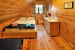 een slaapkamer met een bed in een houten hut bij mazury-dom in Świętajno