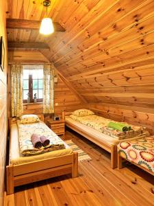 een slaapkamer met 2 bedden in een blokhut bij mazury-dom in Świętajno