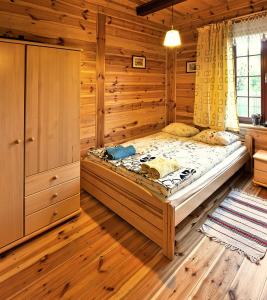 een slaapkamer met een groot bed in een houten kamer bij mazury-dom in Świętajno