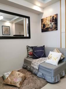ein Schlafzimmer mit einem Bett, einem Sofa und einem Spiegel in der Unterkunft Reese @ Sea Residences Manila in Manila