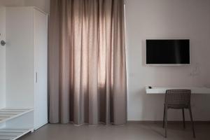 a room with a curtain and a tv and a chair at MaisonMe in Vasto