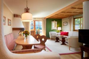 a living room with a table and a couch at Landsitz Römerhof - Hotel Apartments in Kitzbühel