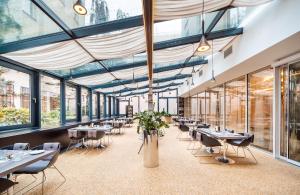 restauracja ze stołami, krzesłami i oknami w obiekcie Grandium Hotel Prague w Pradze