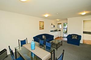 a dining room and living room with a table and chairs at Gateway Motor Inn in Mount Maunganui