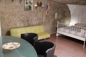 a living room with a table and a crib at Camera Nella Roccia in Tropea