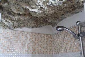 a dirty ceiling in a bathroom with a shower at Camera Nella Roccia in Tropea