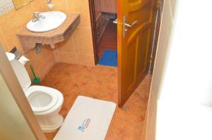 a bathroom with a toilet and a sink at Pavilion Holiday Resort in Bamburi