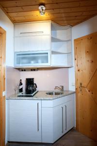 a kitchen with white cabinets and a sink at Gästehaus Elisabeth in Oberaichwald