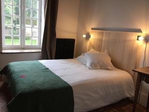 - une chambre avec un grand lit blanc et une fenêtre dans l'établissement Orangerie du chateau de Quemigny sur Seine, à Quemigny-sur-Seine