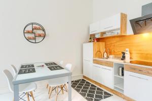 a kitchen with a table and chairs and a counter at Apartament Miły in Gorzów Wielkopolski
