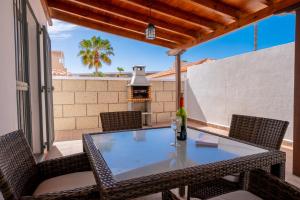a table and chairs on a patio with a grill at Villa Iris in Callao Salvaje