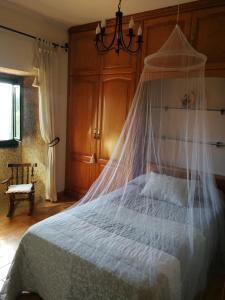een slaapkamer met een bed met een klamboe bij CASA O QUINTEIRO in Vimianzo