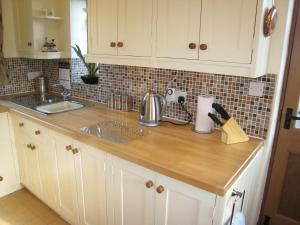 a kitchen with a sink and a counter top at Measure Cottage - Sleeps 5 - Private Hot tub and garden in Henley in Arden