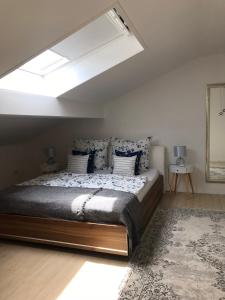 a bedroom with a large bed with a skylight at Haus DreiSeenBlick in Rimsting