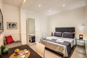 ローマにあるColosseo Suite Apartmentのベッドルーム1室(ベッド1台、ソファ、テーブル付)