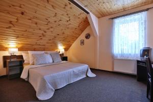 Tradice (U Bendů) في Pernink: غرفة نوم بسرير كبير وسقف خشبي