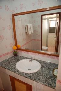 a bathroom with a sink and a mirror at Rose Garden Hotel in Phra Nakhon Si Ayutthaya