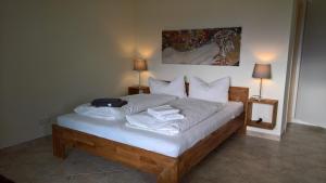 a bedroom with a bed with white sheets and pillows at Appartementhaus Süssling in Glowe