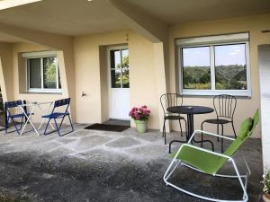 eine Terrasse mit Stühlen, Tischen und Fenstern in der Unterkunft Les Agapanthes Site de Fondettes in Fondettes