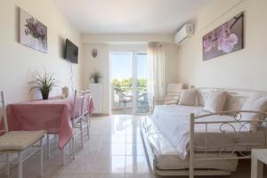 a bedroom with a bed and a table and chairs at Lovely Apartment Xylokastro 2nd Floor in Xylokastron