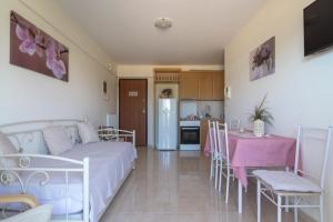Zimmer mit einem Bett und einem Tisch sowie einer Küche in der Unterkunft Lovely Apartment Xylokastro 2nd Floor in Xylokastro