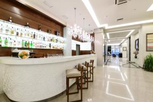 エレバンにあるOpera Suite Hotelのスツール付きのバーのあるホテルのロビー