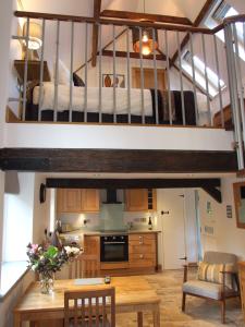 a kitchen and living room with a loft at The Barn in Redlynch