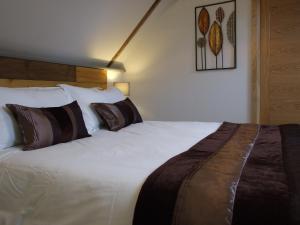 a bedroom with a large white bed with pillows at The Barn in Redlynch
