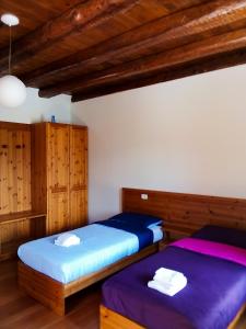 two beds in a room with wooden cabinets at La casa del popolo in Prato Carnico