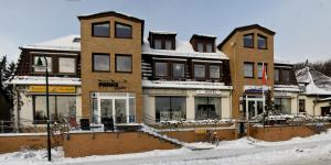 a large brick building with snow on the ground at Hotel "Zur Panke" in Panketal