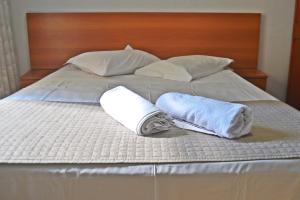 1 cama con 2 toallas y 2 almohadas en Hotel Ampiezza, en Curitiba