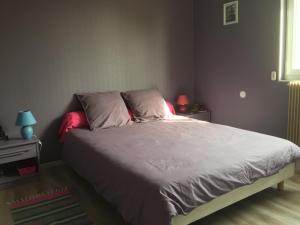 a bedroom with a bed with white sheets and pink pillows at Jolie halte normande in Balines