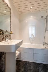 a white bathroom with a sink and a tub at Hotel Diana Paris in Paris