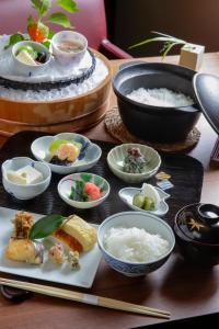 a table with plates of food and bowls of rice at Kaminarimon Ryokan in Tokyo