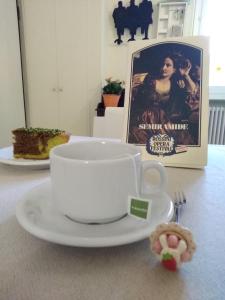 a cup of coffee on a plate with a cookie at Il Vicolo 48 in Pesaro