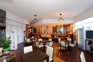 um restaurante com mesas e cadeiras e um bar em Hotel Frate Sole em Assis