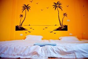 a bedroom with a bed with palm trees and birds at Sronghld 128 B&B in Jinning