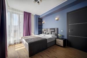 Un dormitorio con una cama con paredes azules y una ventana en Hotel Luidor, en Tver