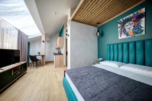 1 dormitorio con 1 cama grande y pared azul en Hotel Luidor, en Tver